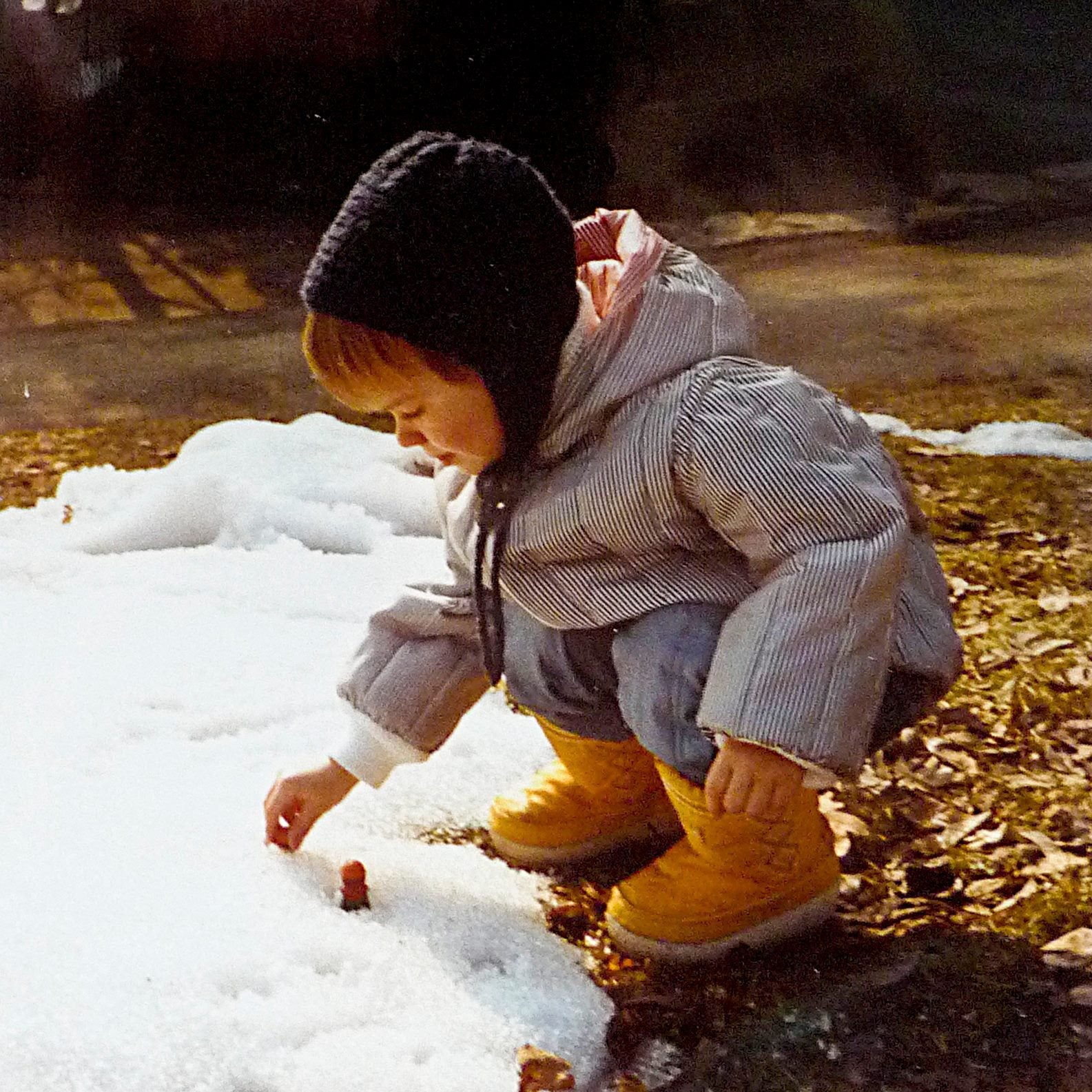 Une fille d'environ cinq ans joue dans la neige